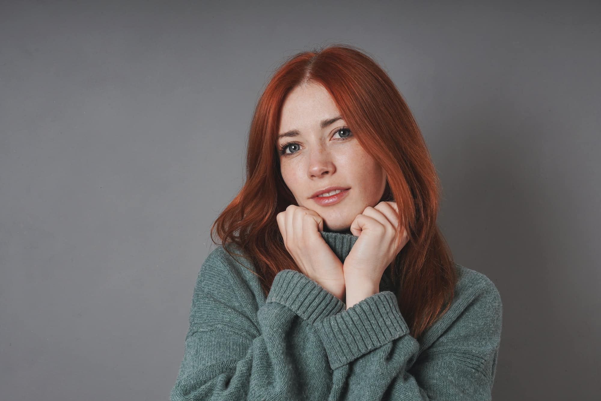 young woman snuggling into warm turtleneck sweater
